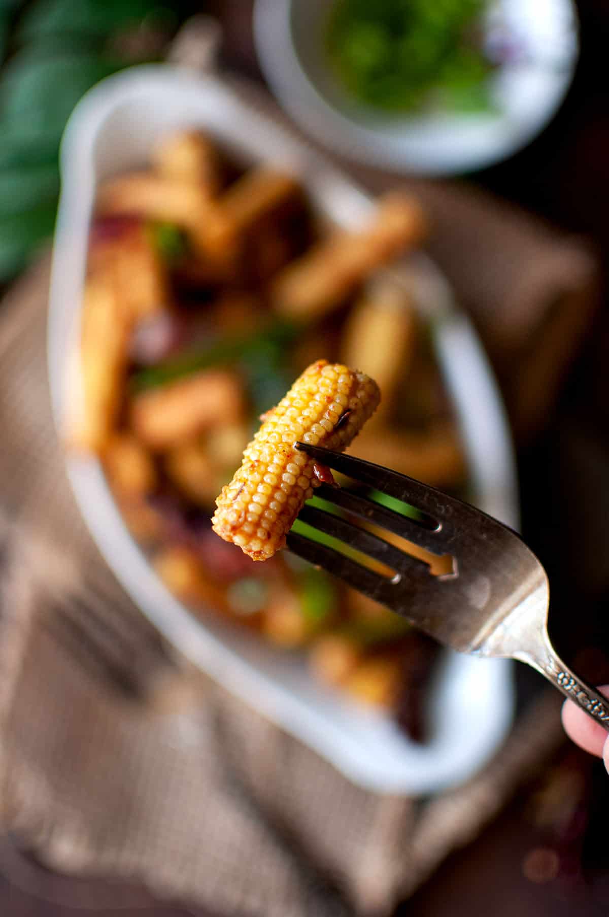 Fork with roasted baby corn.