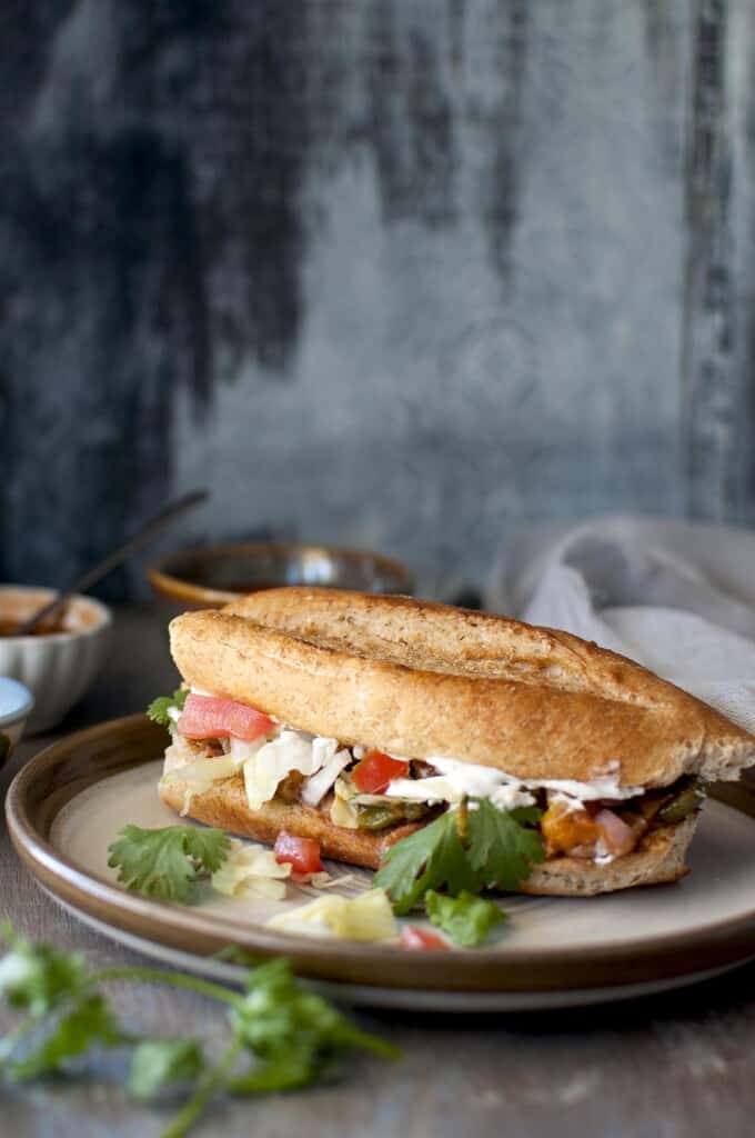 grey plate with vegetable filled sandwich