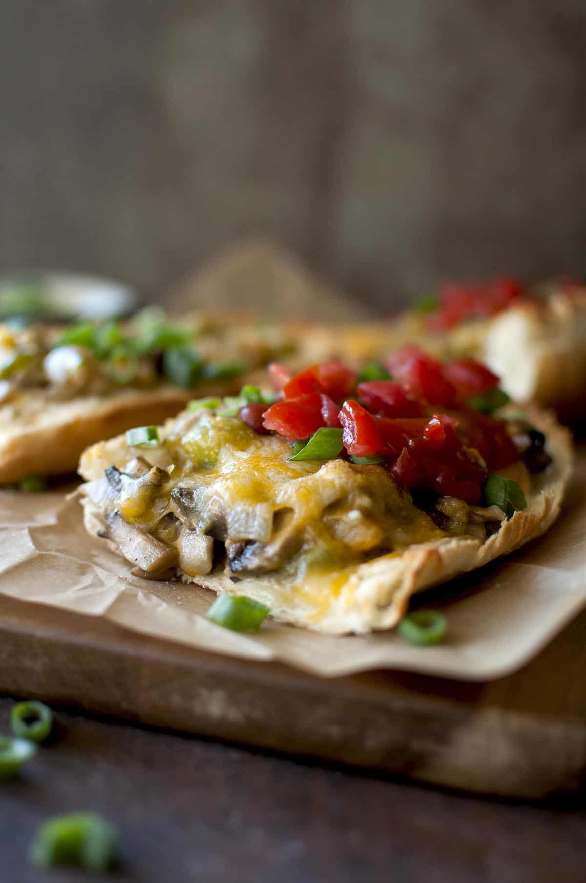 Baking sheet with mushroom and cheese open face sandwich.