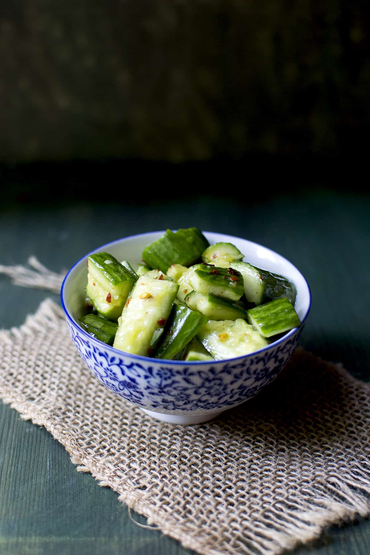 white and blue bowl with smashed cucumber salad