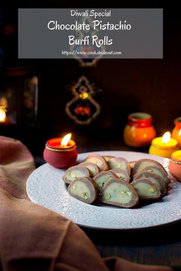 Plate of pista burfi with lit lamps for Diwali