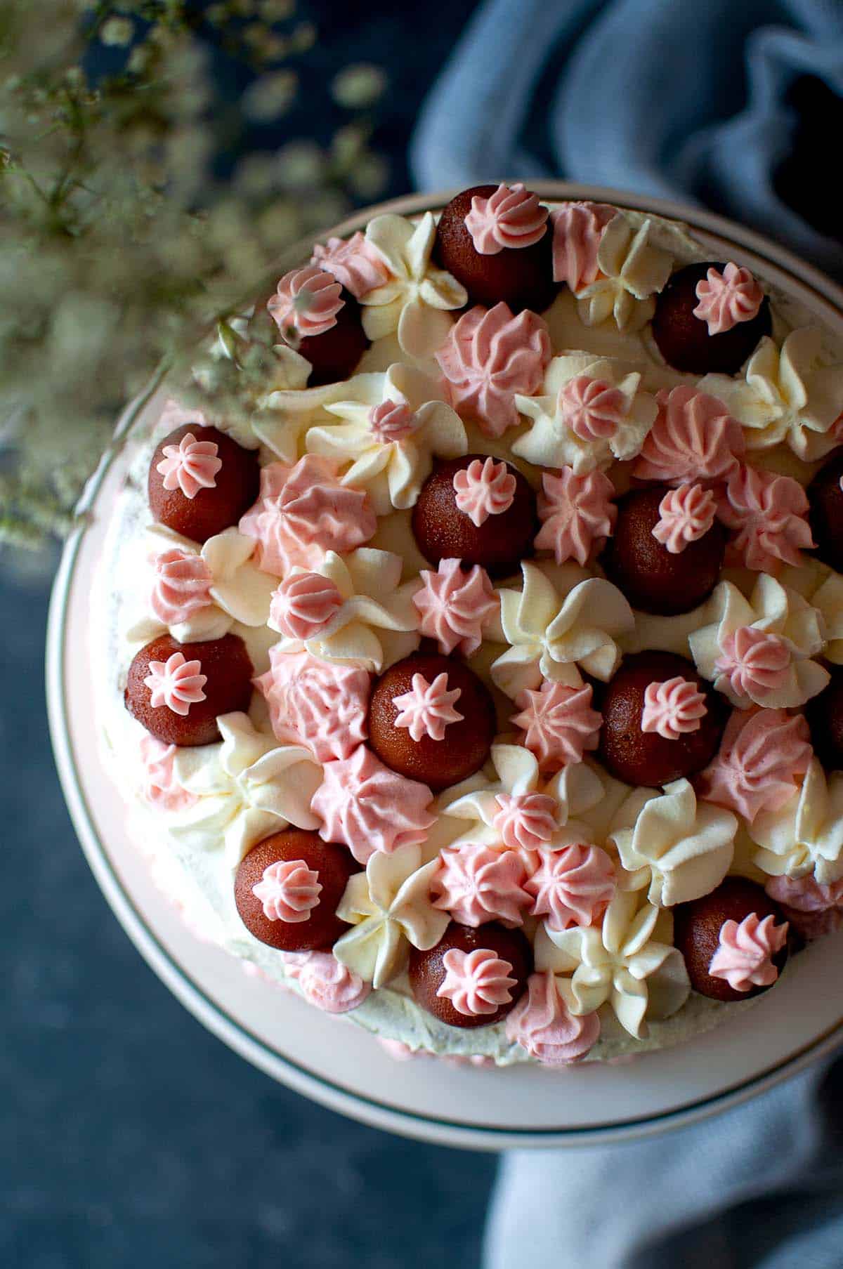 Top view of a decorated cake with jamun and frosting