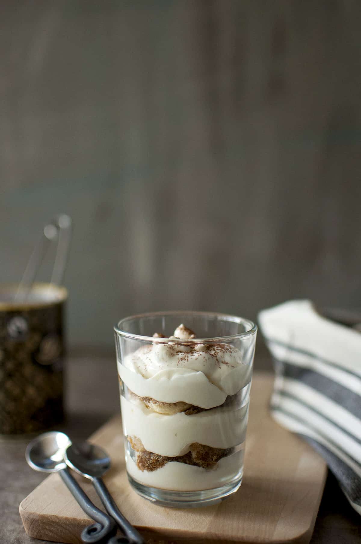 Glass with lady fingers layered with cream filling and topped with cocoa powder