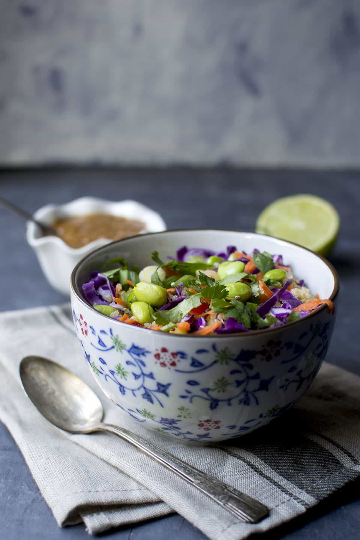 White bowl with Thai quinoa salad topped with edamame