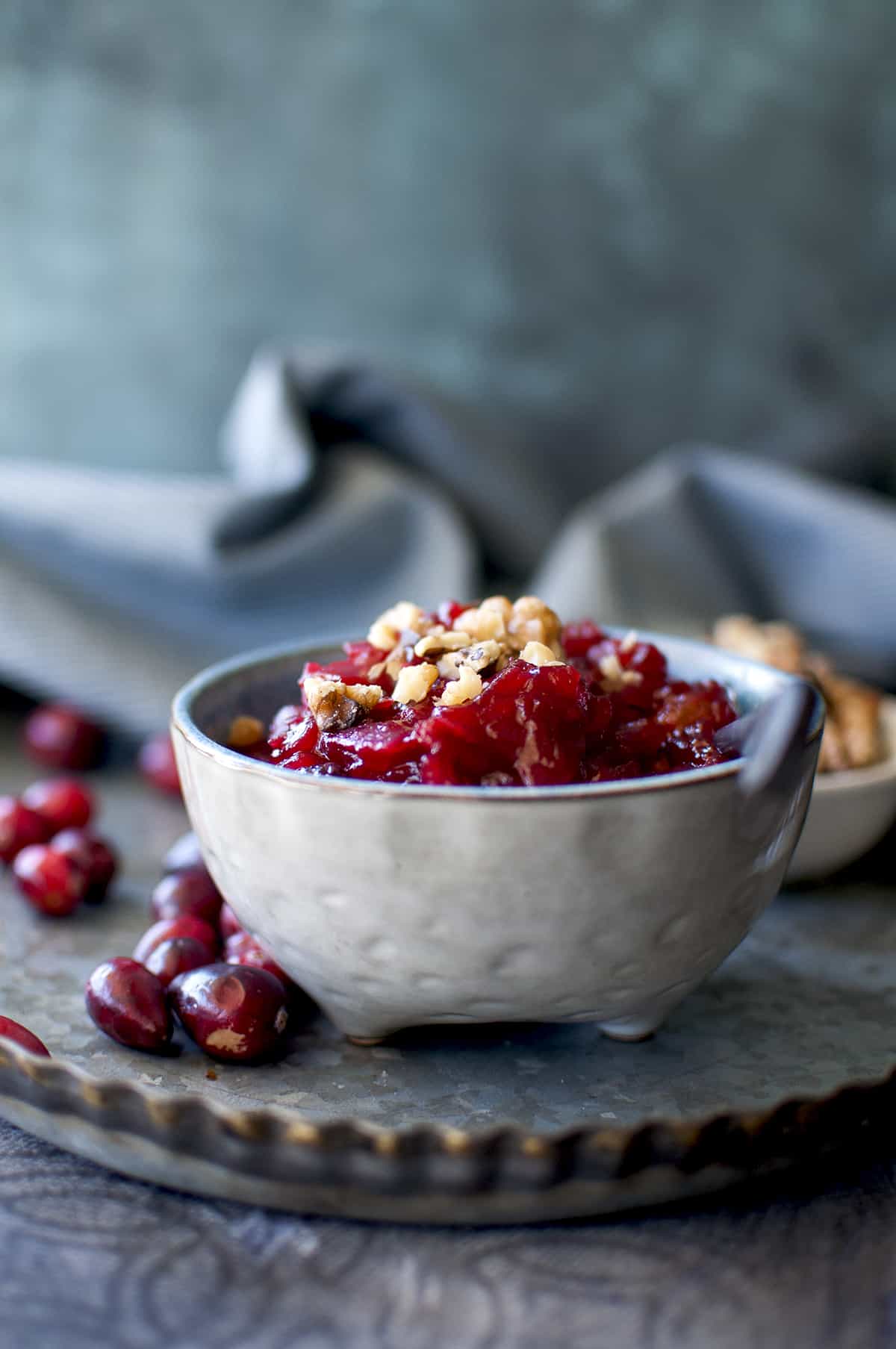 Blue bowl with chutney topped with chopped walnuts.