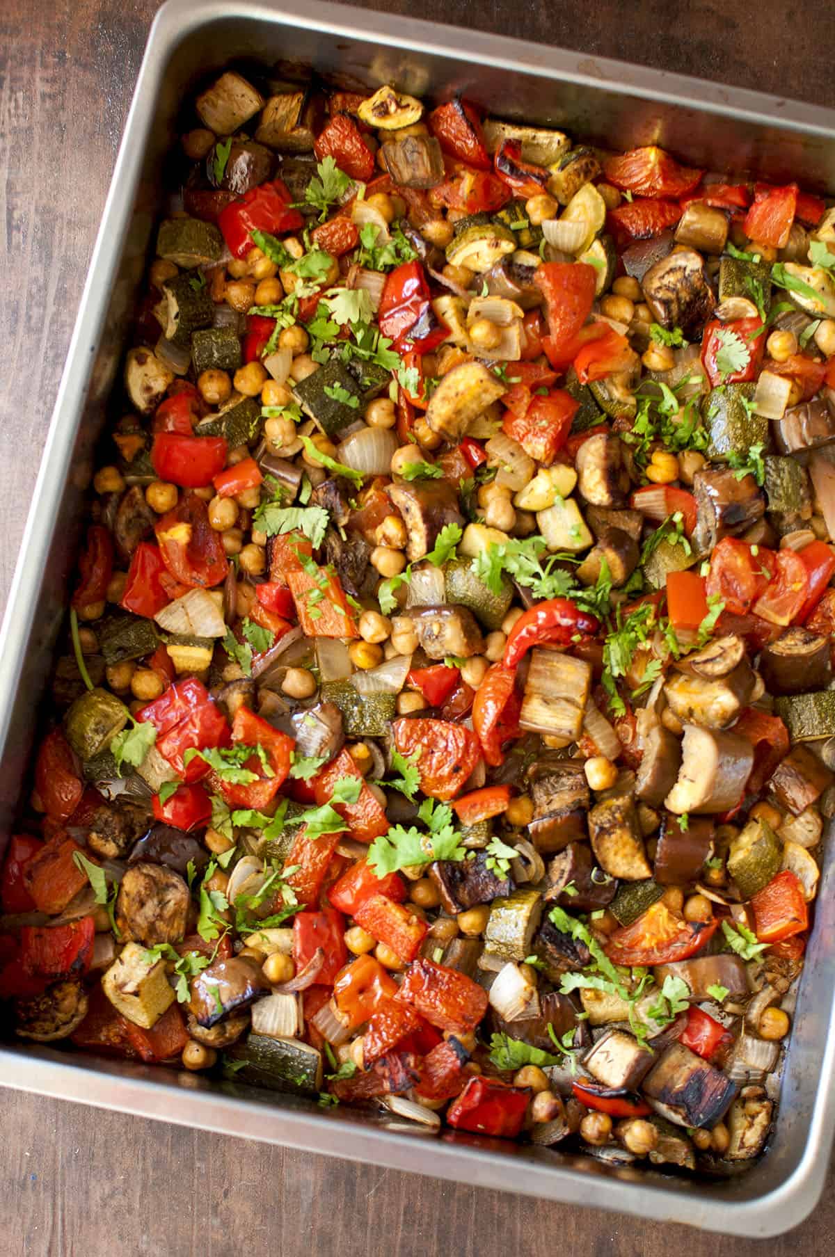 Roasting pan with roasted vegetables sprinkled with fresh herbs