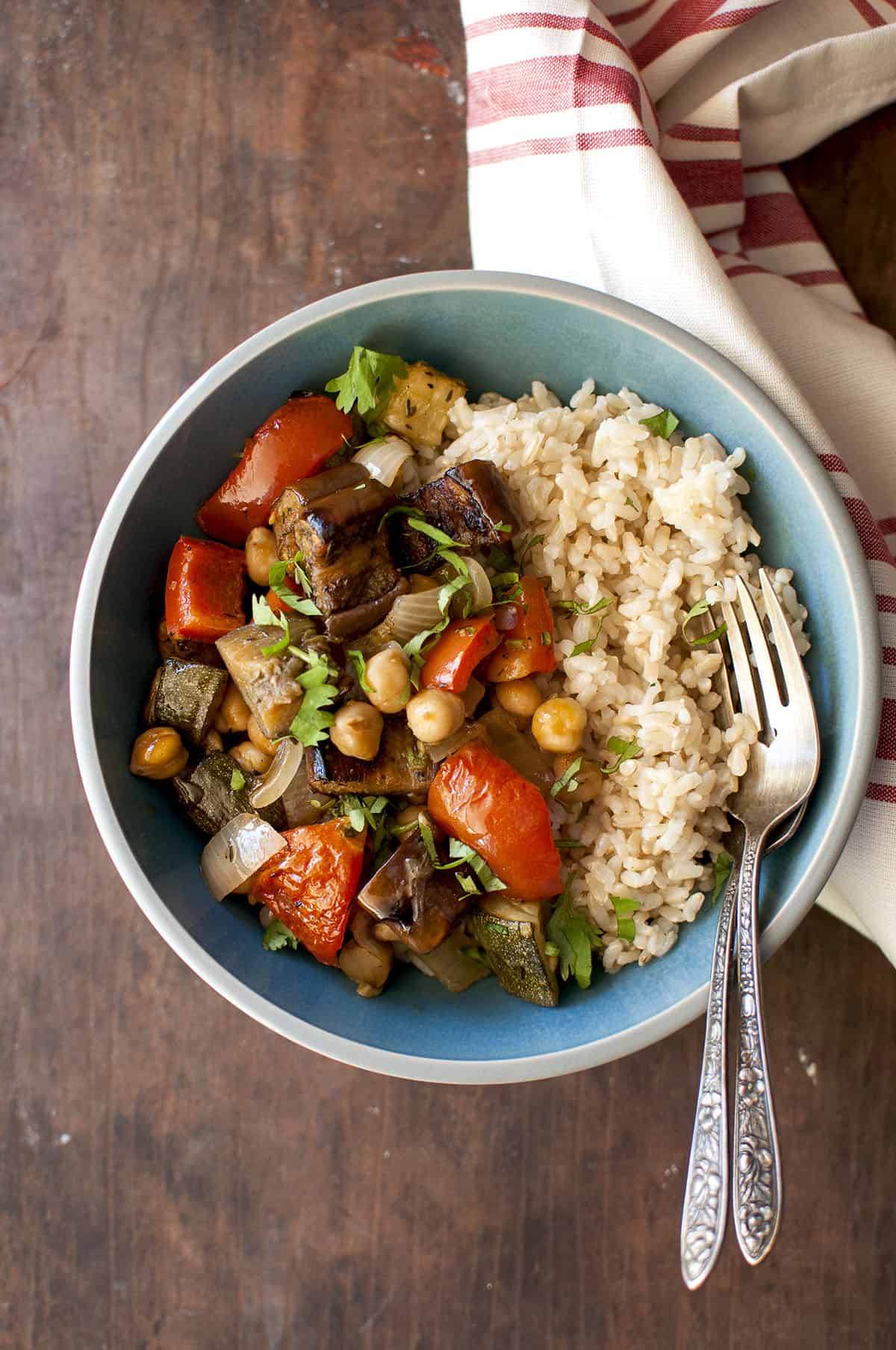 Blue bowl with half roasted veggies and half brown rice