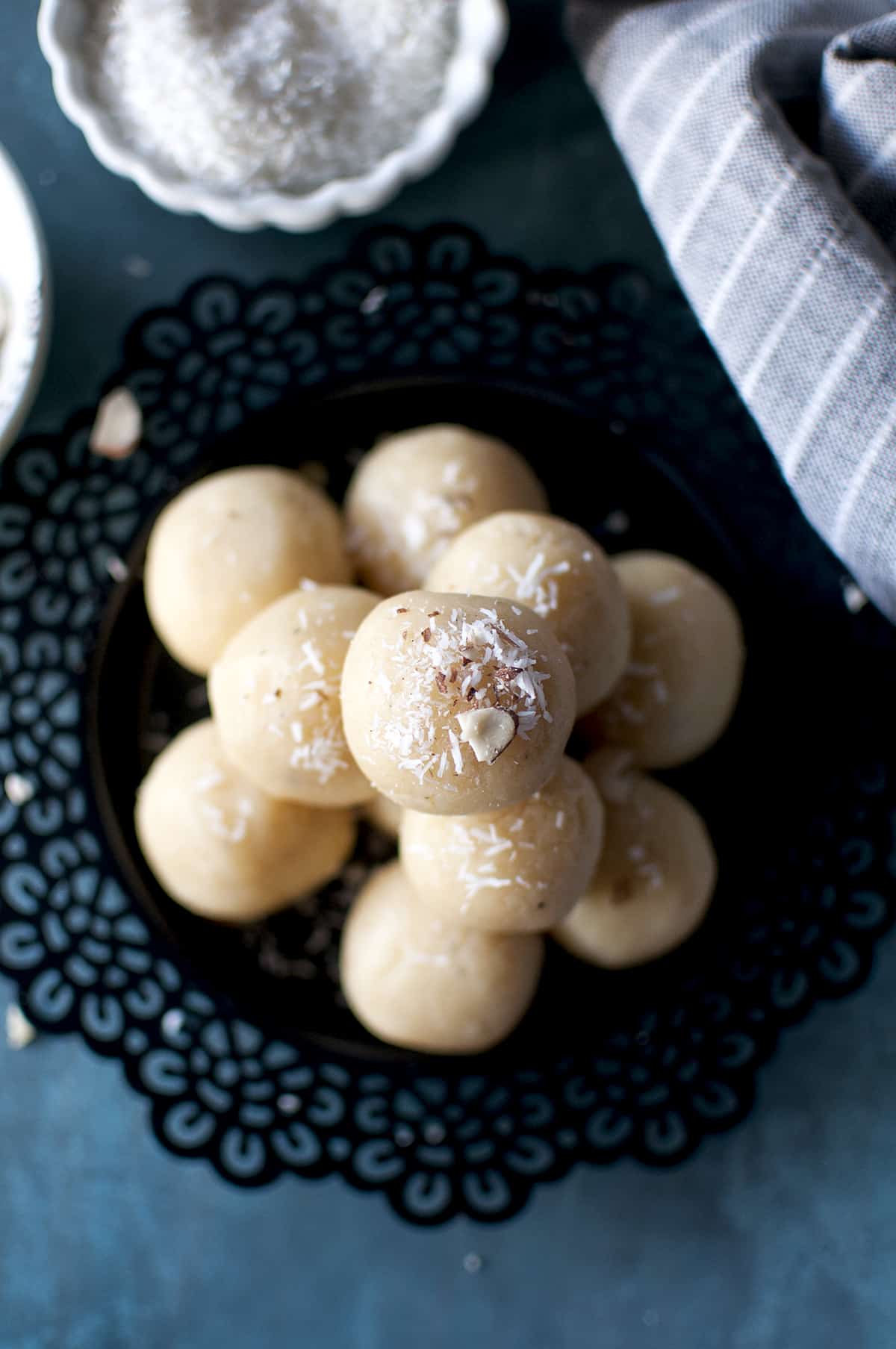 Black plate with a stack of coconut malai ladoo.