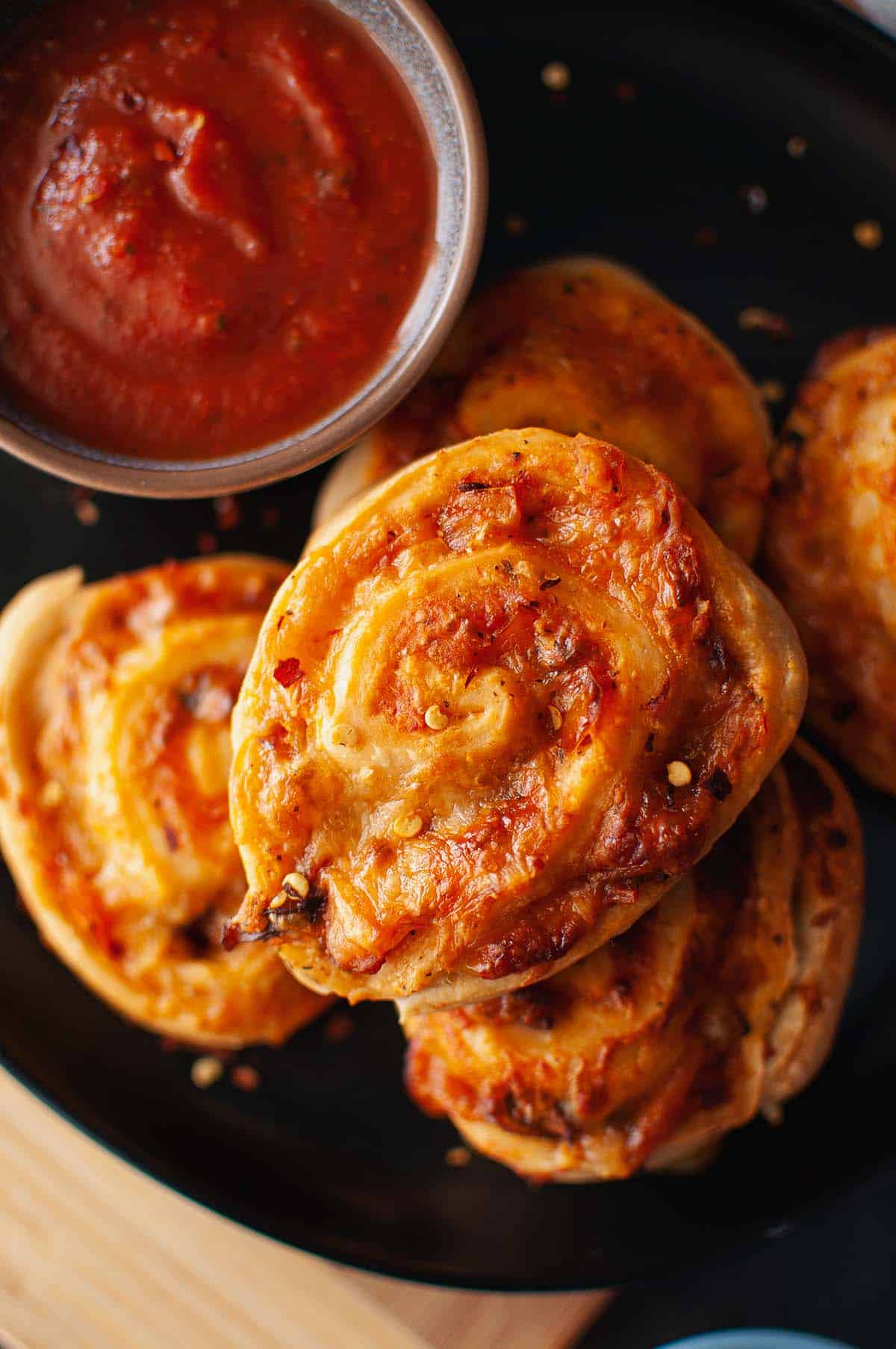 Top view of black plate with pizza buns.