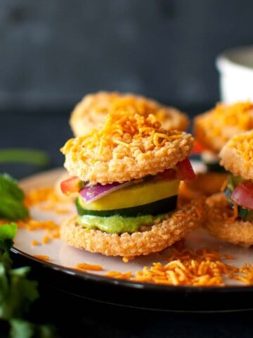 White plate with chakli and veggie sandwich.