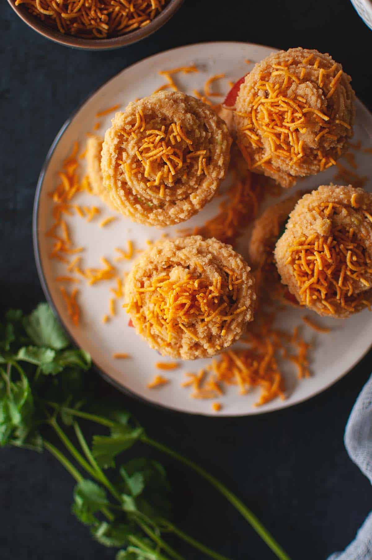 White plate with 4 murukku sandwich topped with sev.