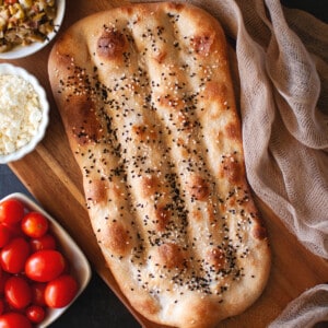 Wooden board with Nan e barbari bread.