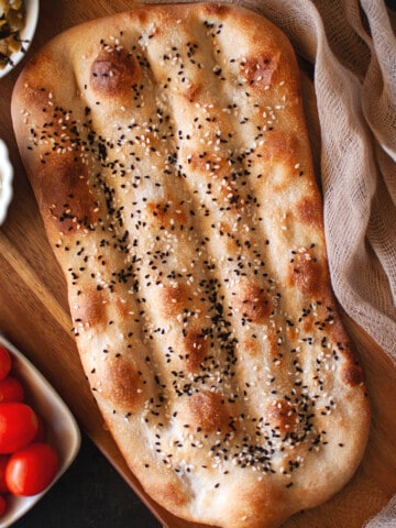 Wooden board with Nan e barbari bread.