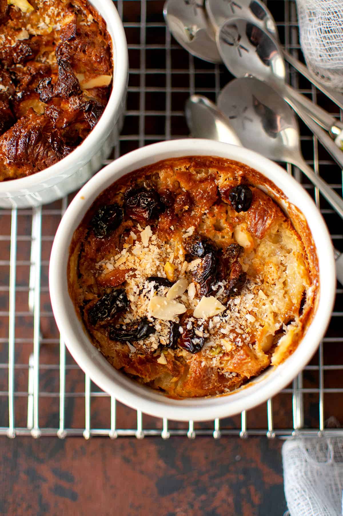 Steel cooling rack with baked oum ali in white ramekin.