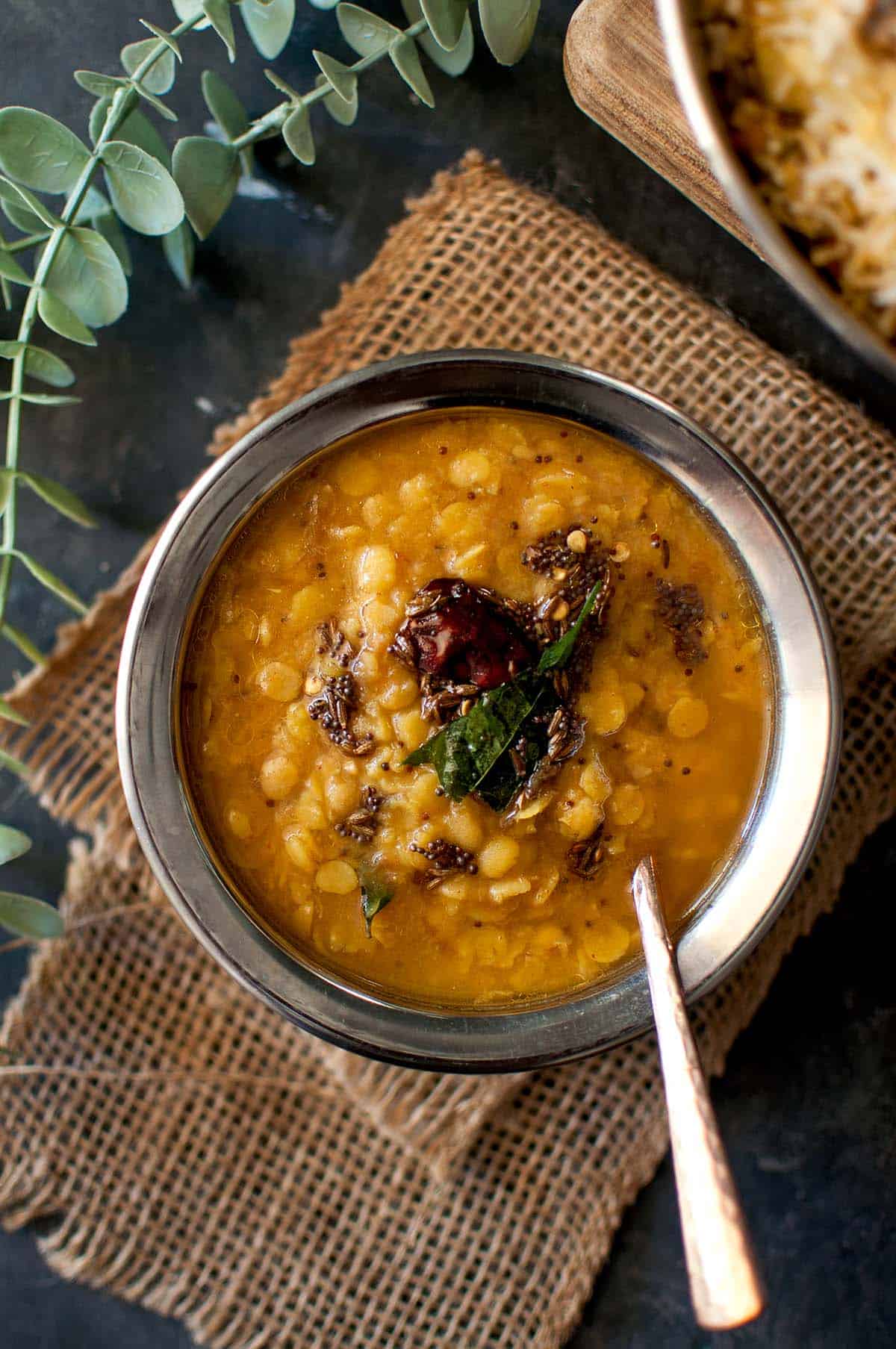 Steel bowl with lentil stew topped with tadka