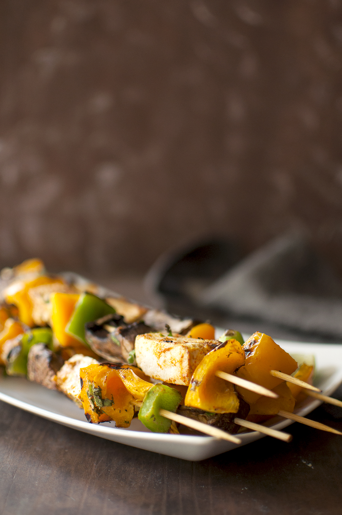 White platter with a stack of grilled skewers