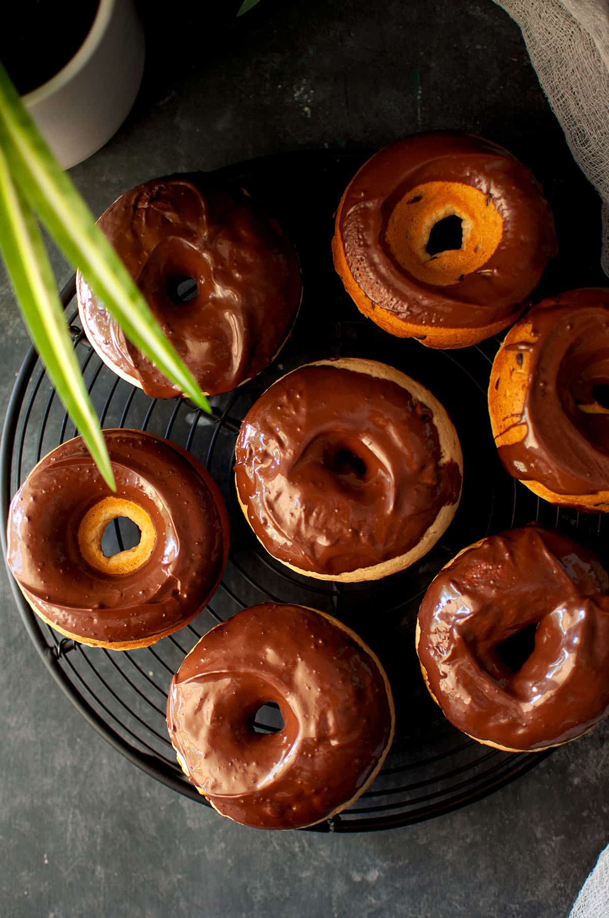 Black wire rack with eggless chocolate chip donuts.