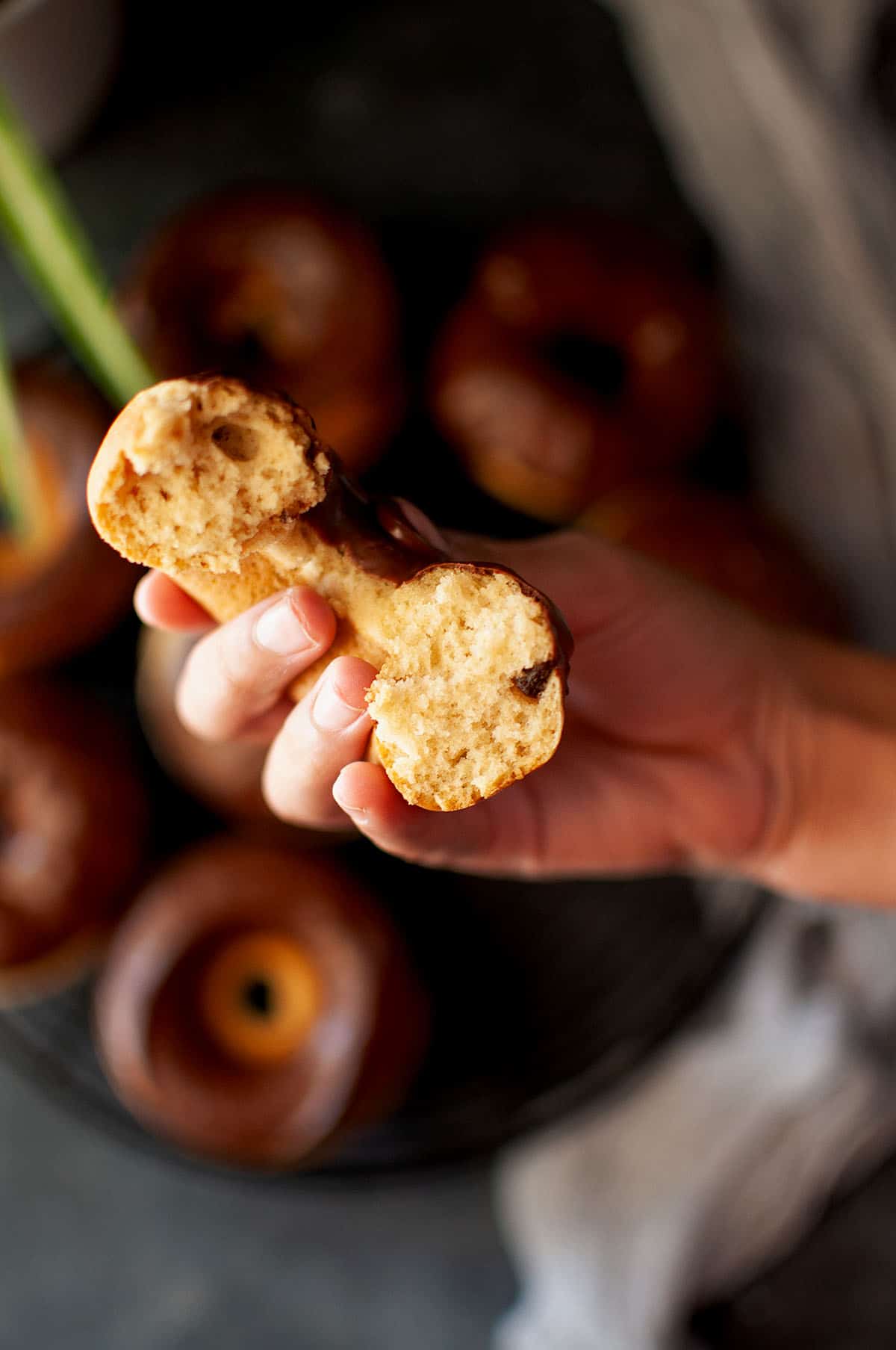 Hand holding half a donut.