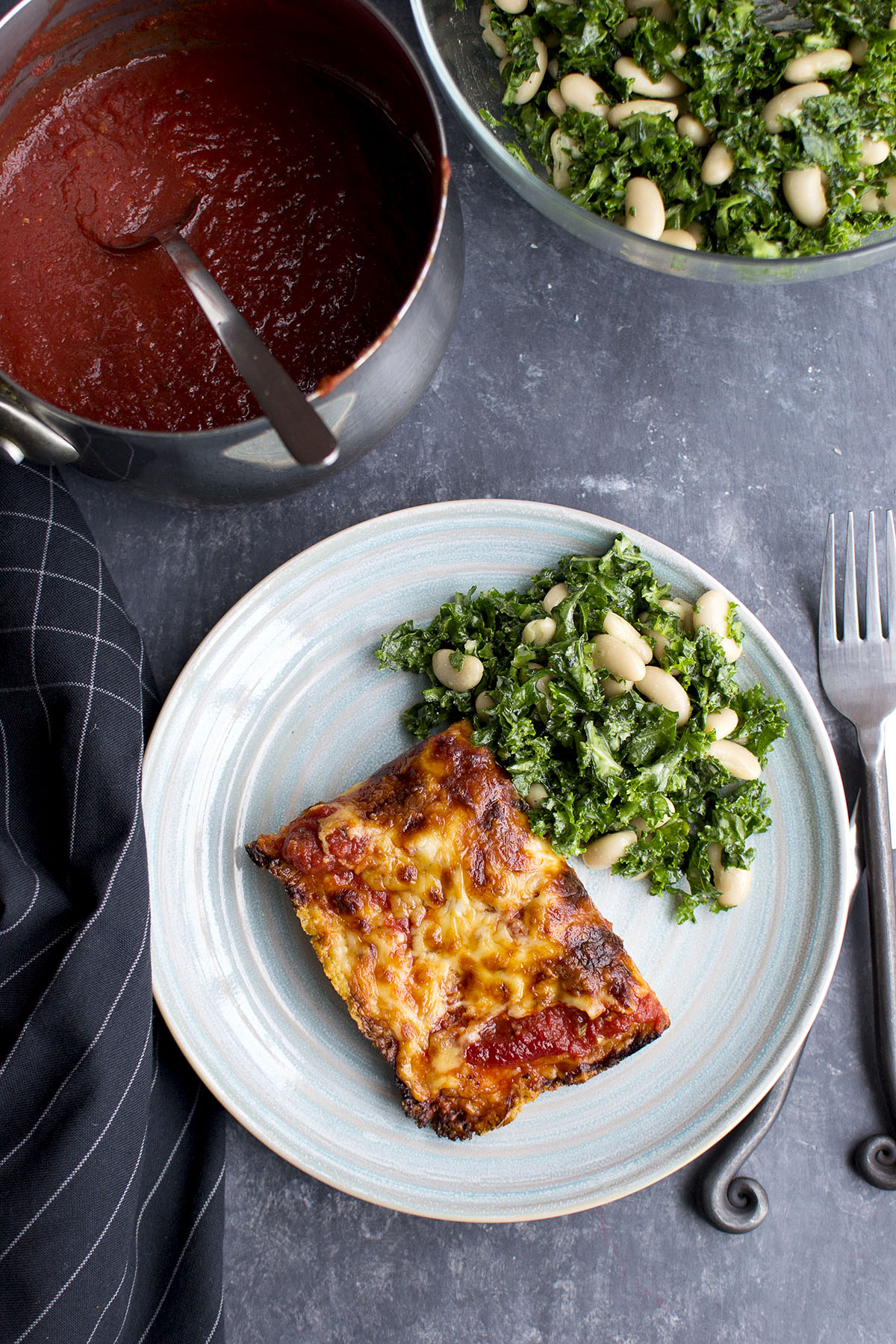 Blue plate with Detroit Style pizza slice and green salad