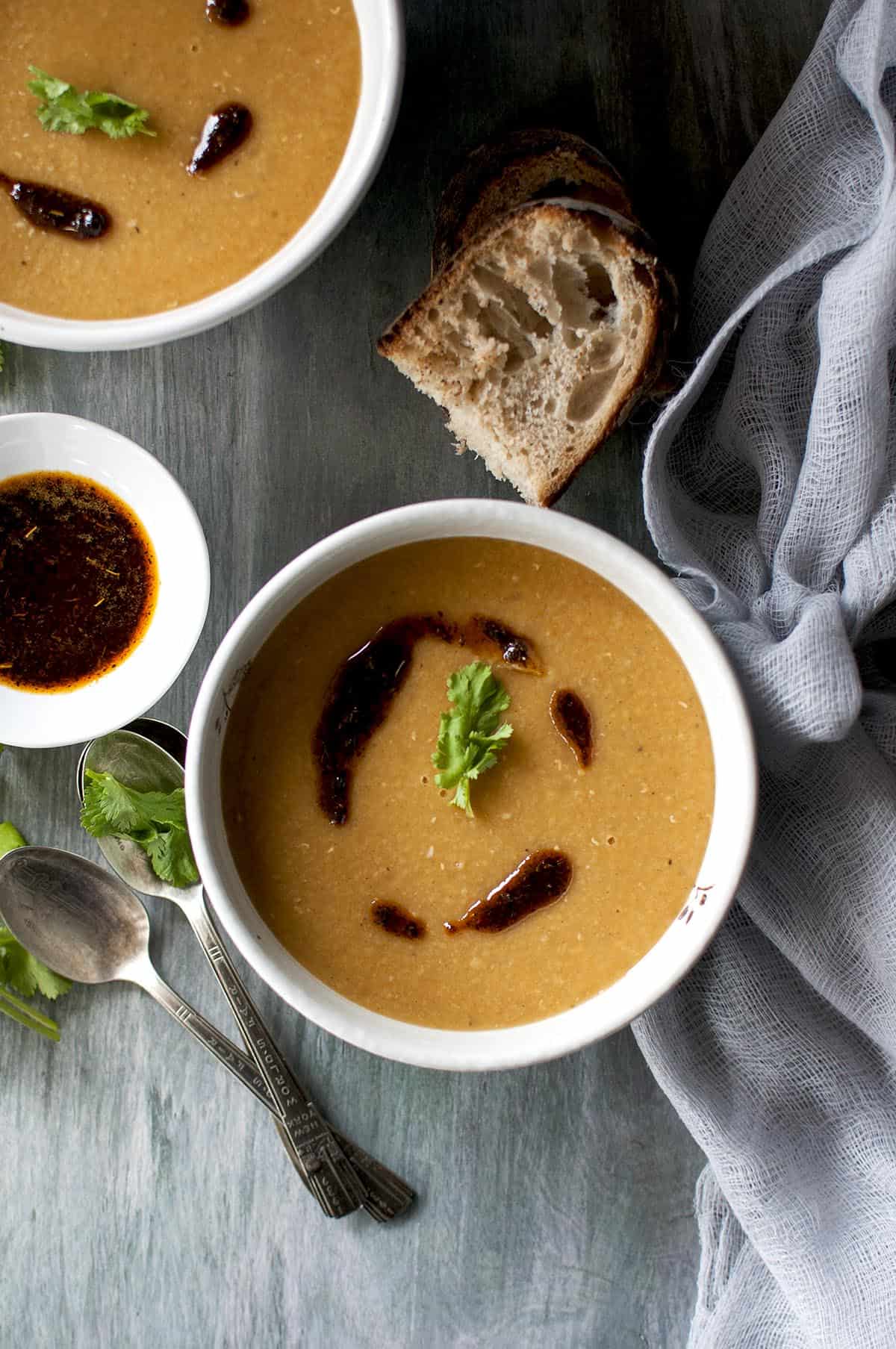 White bowl with Moroccan red lentil soup topped with spiced butter