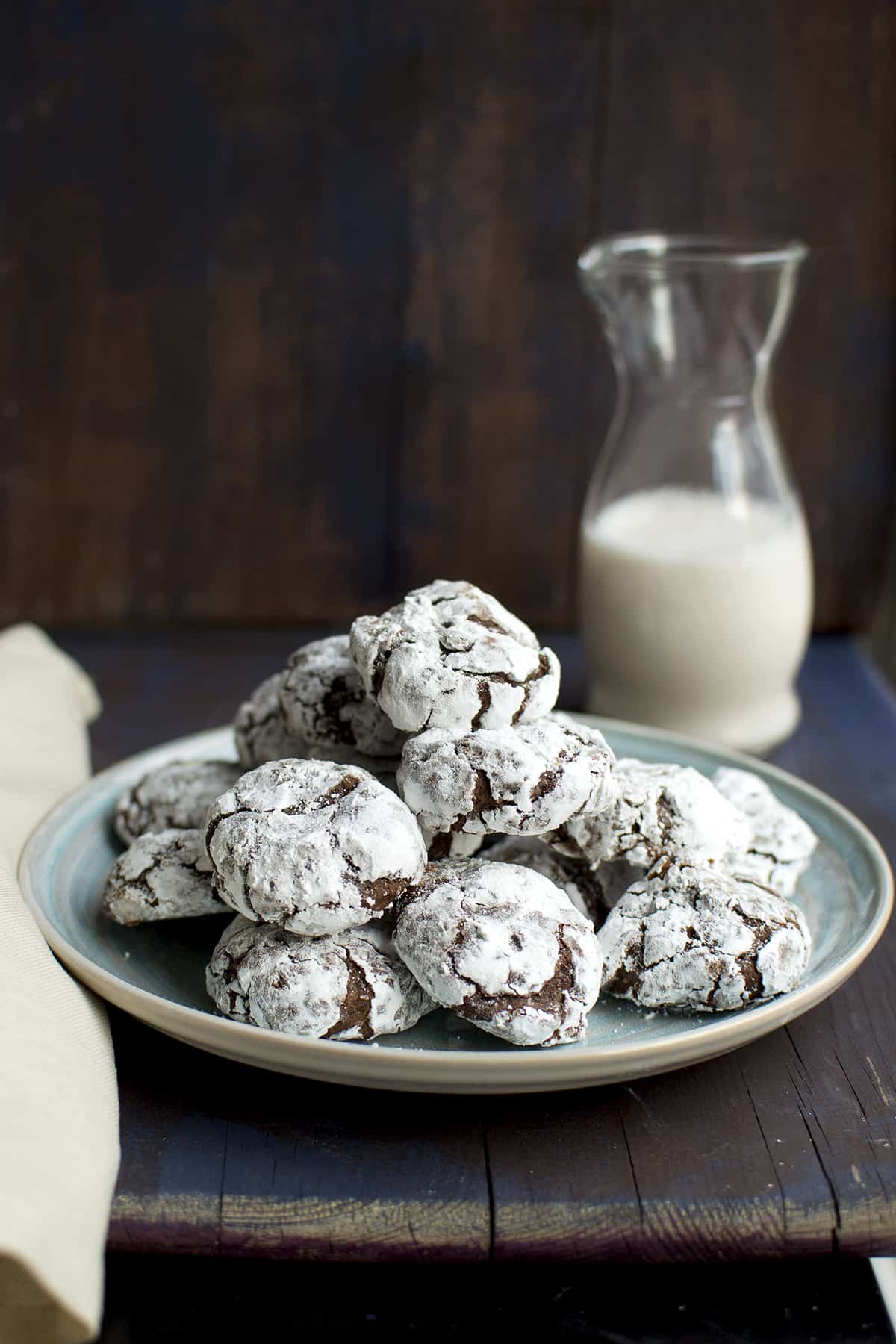 Blue plate with a stack of cookies and a glass bottle with milk in the background