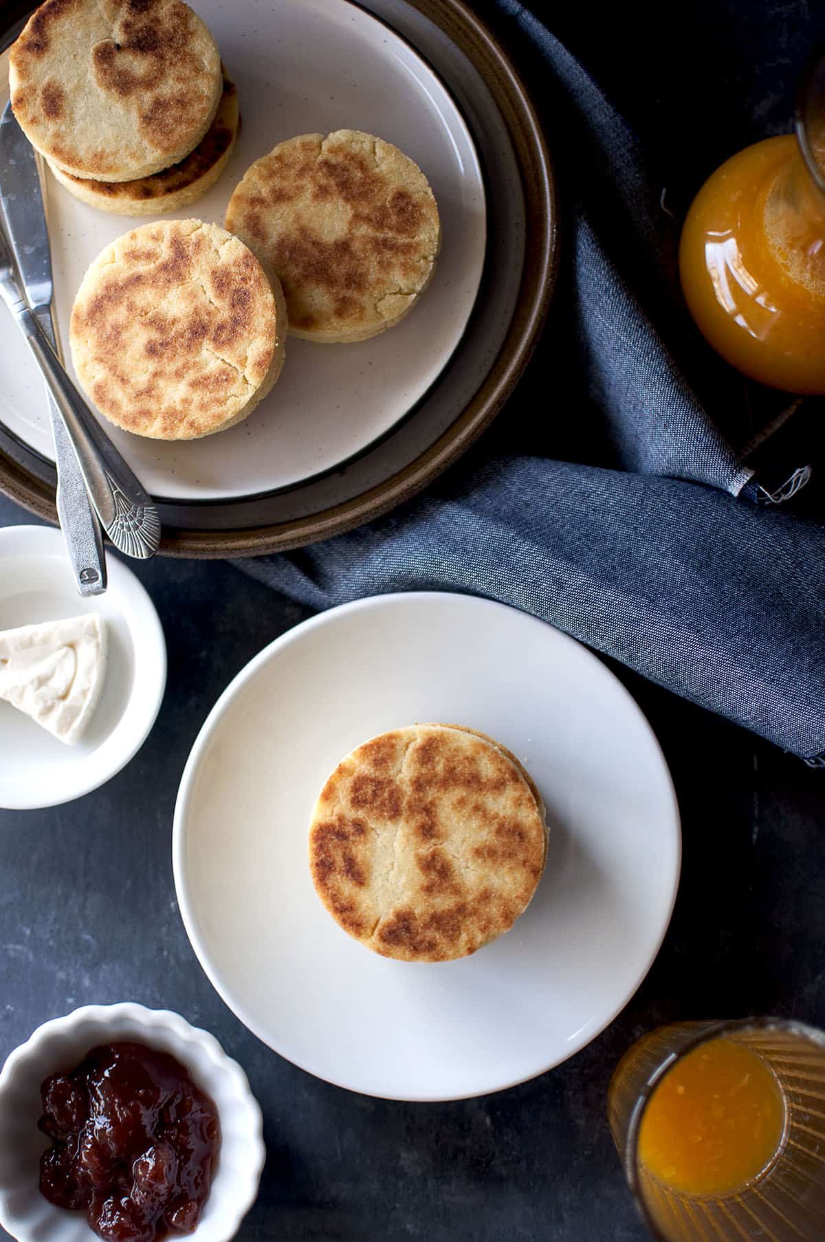 White plate with crispy semoliana flatbread with small bowls with jam and cheese