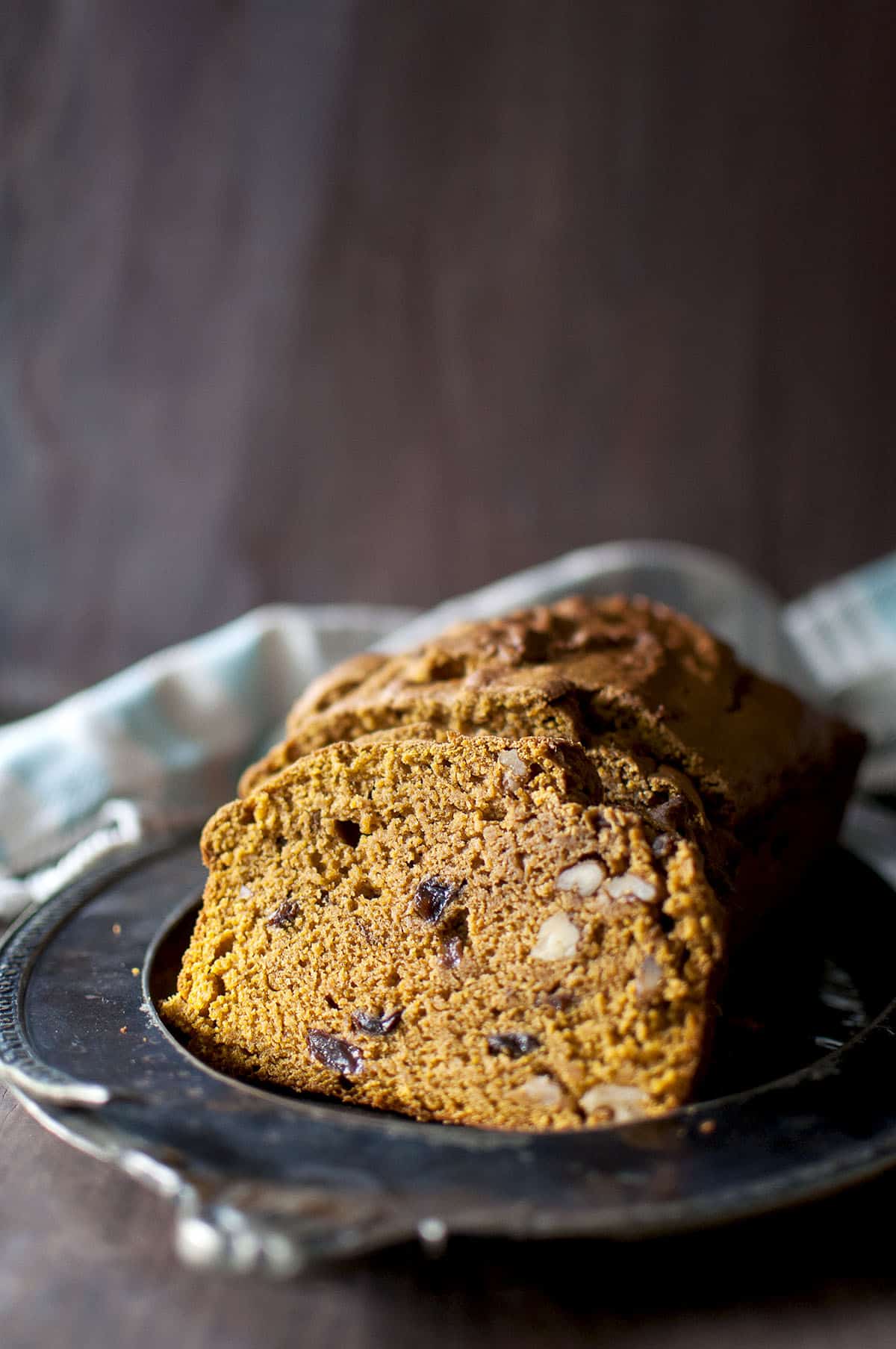 Plate with slices of raisin & walnut studded sourdough pumpkin bread