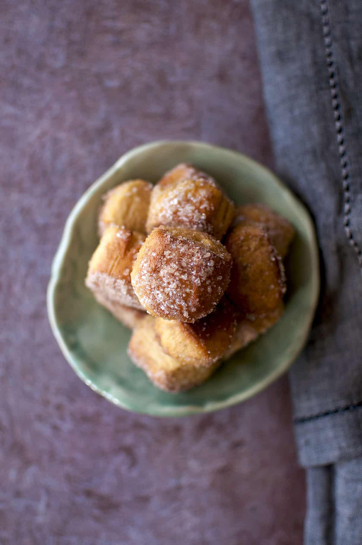 Green plate with a stack of cinnamon sugar pretzel bites