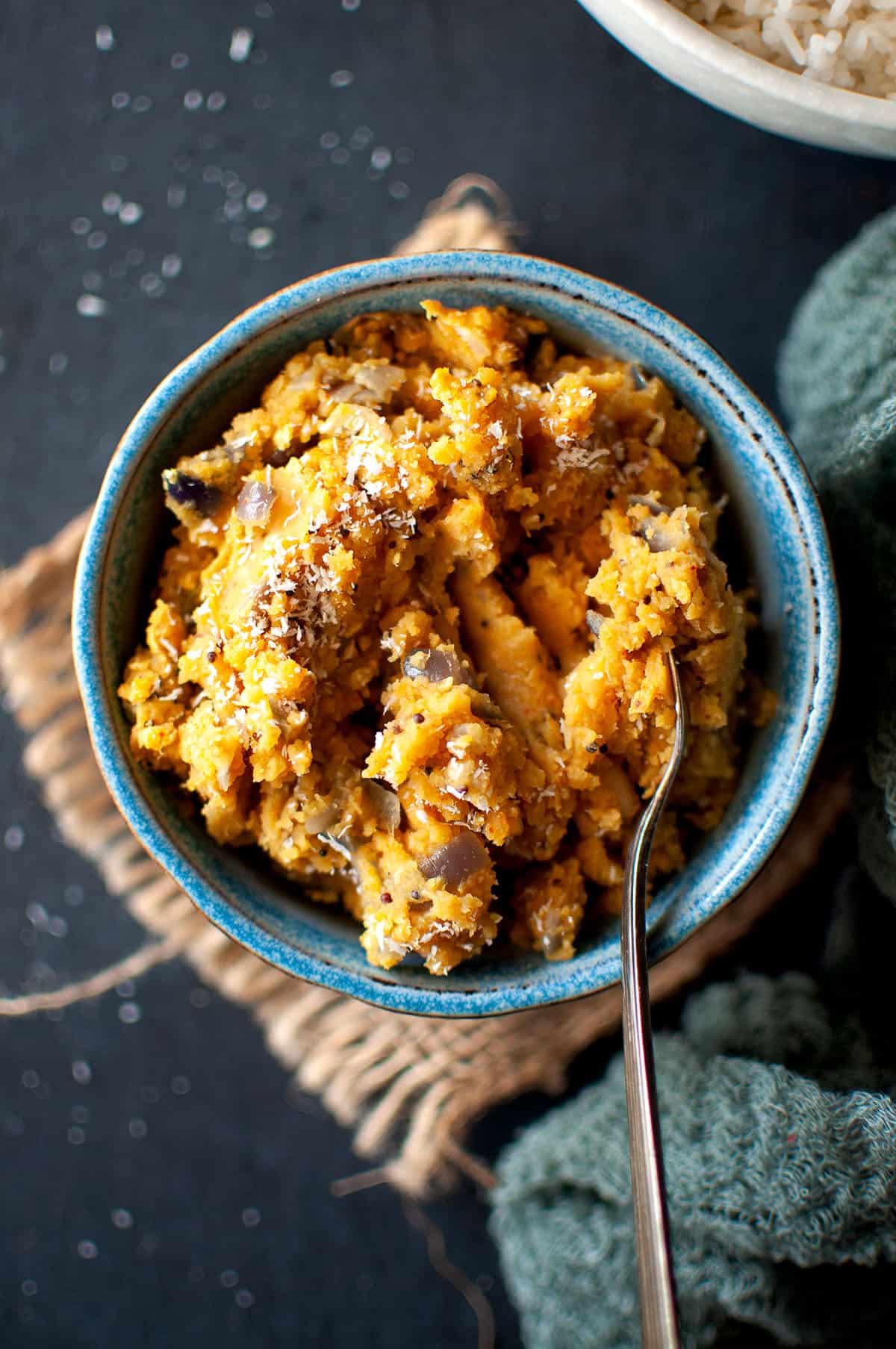 blue bowl with Sri Lankan dhal curry and a spoon.