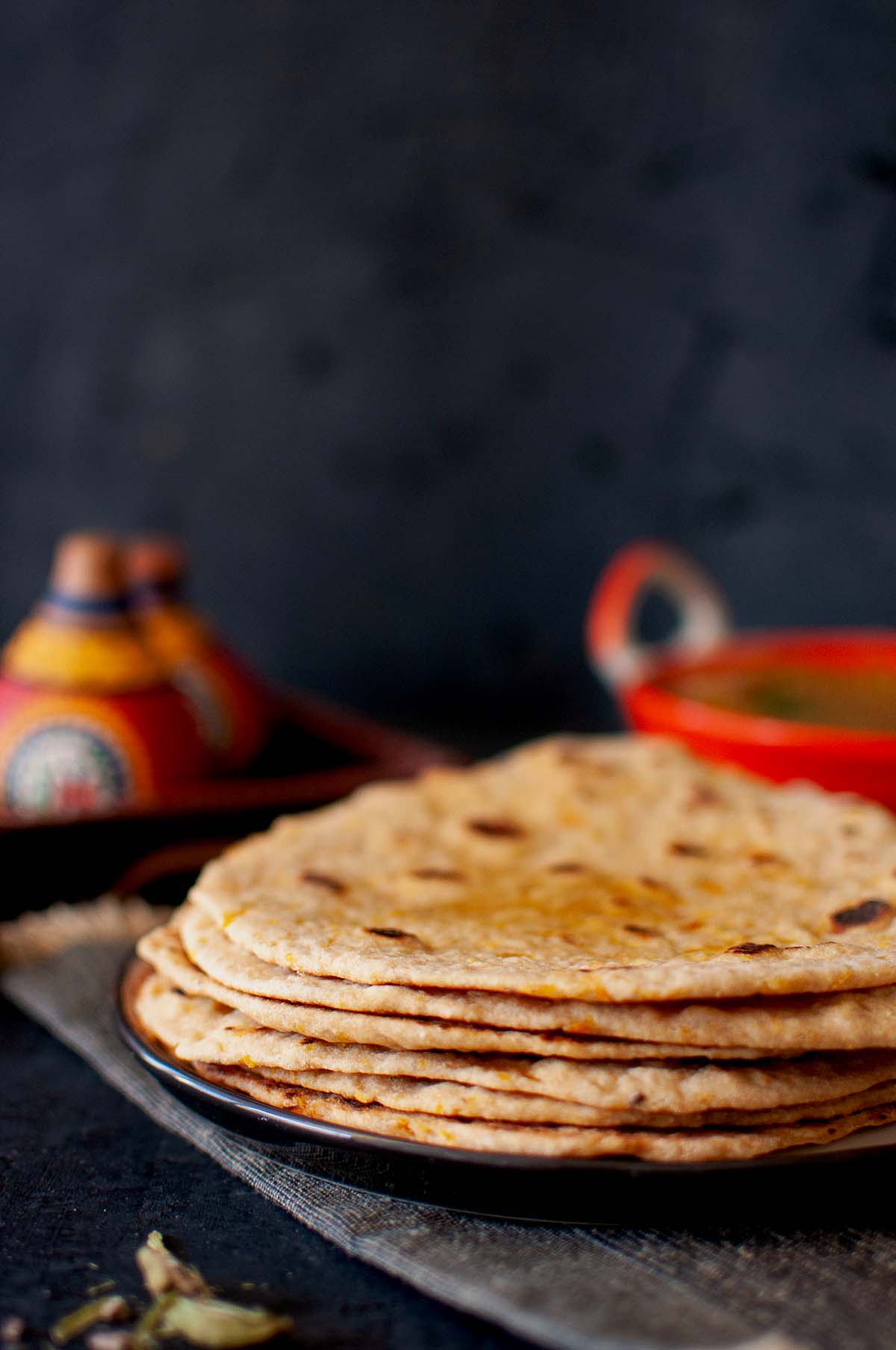 Black plate with a stack of pumpkin roti