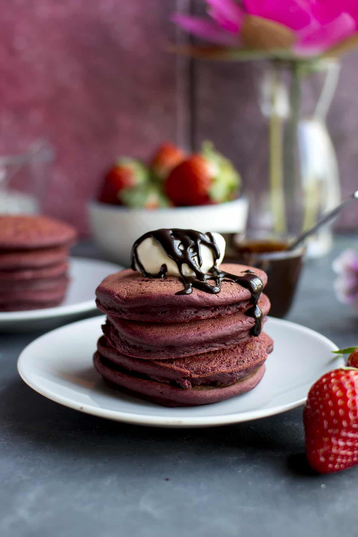 White plate with a stack of red velvet pancakes