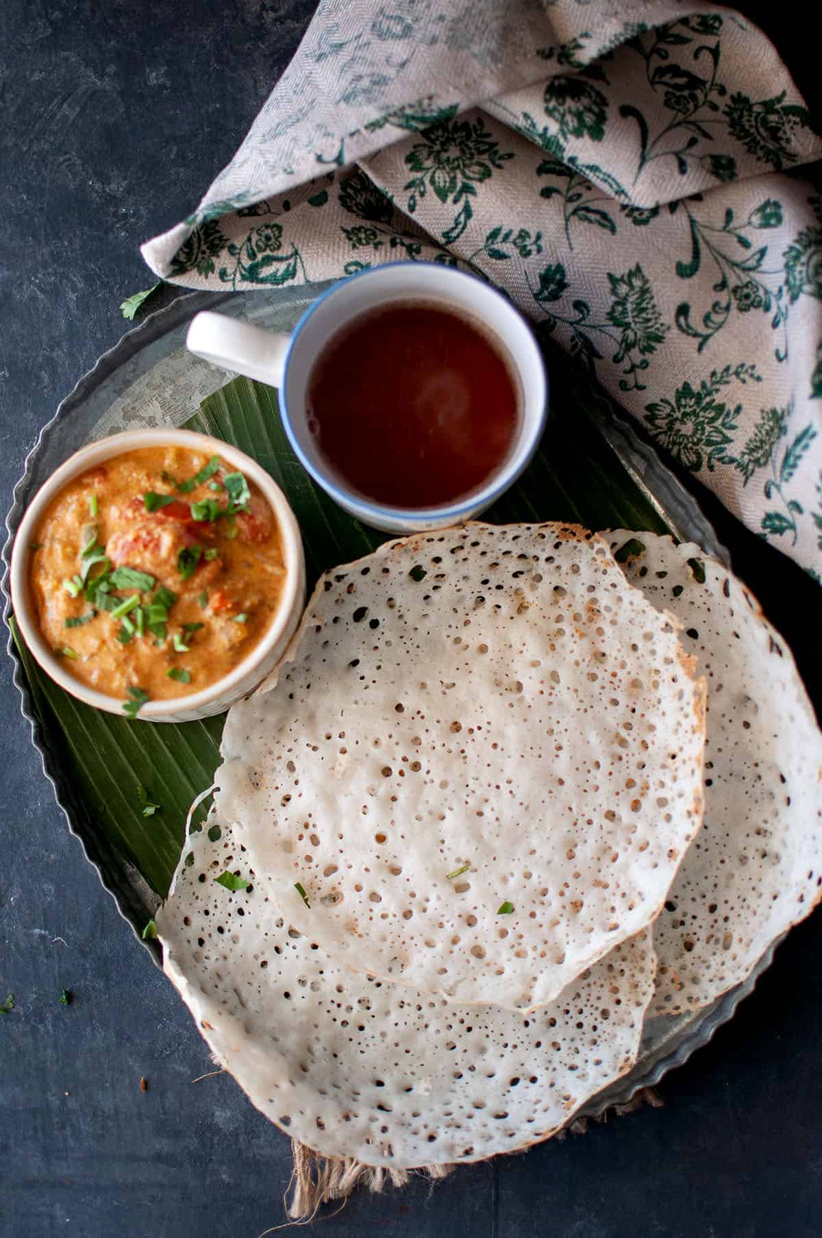 Breakfast platter with South Indian crepes with curry and tea.