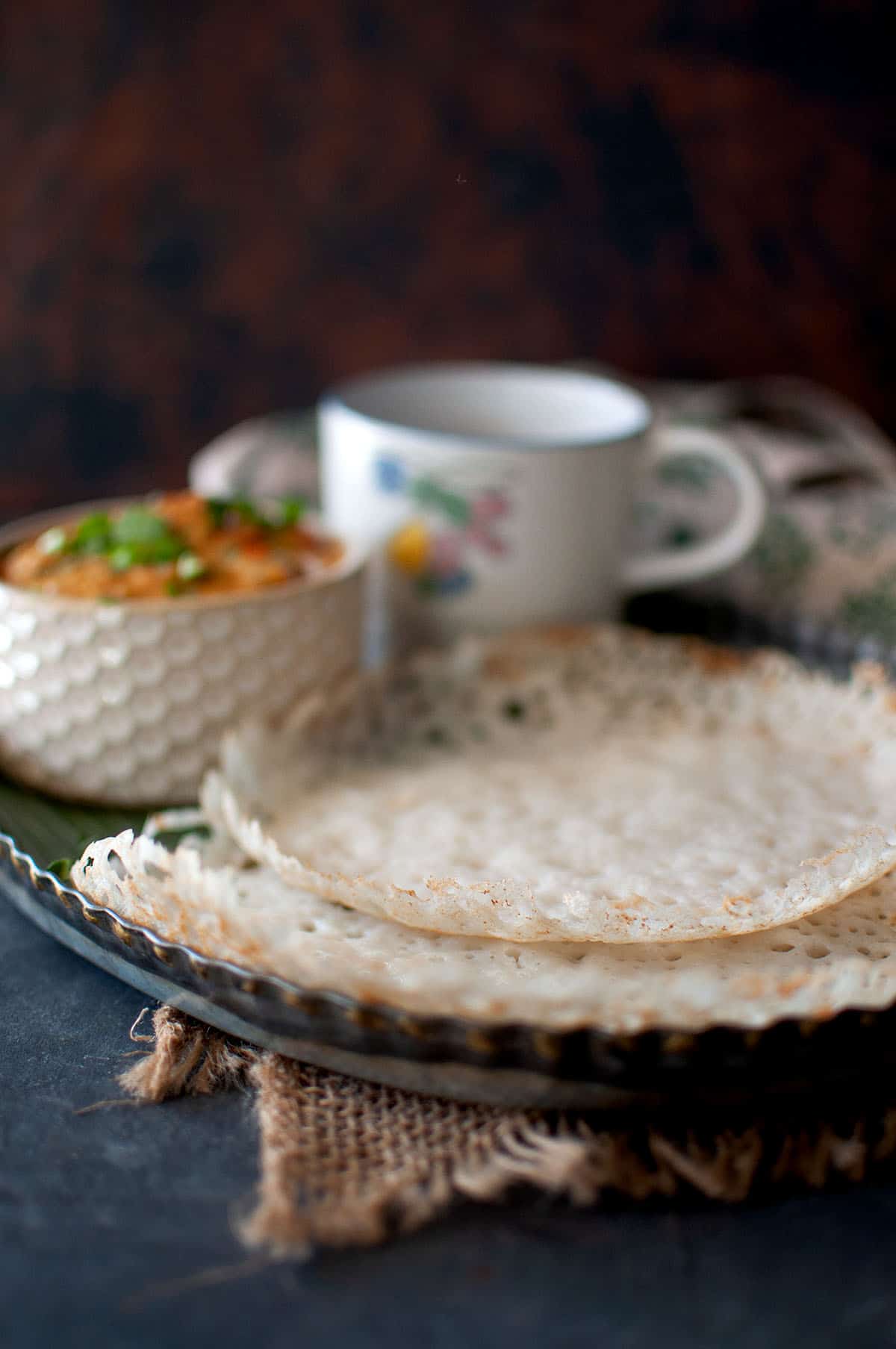 Lacy appam in a tray.