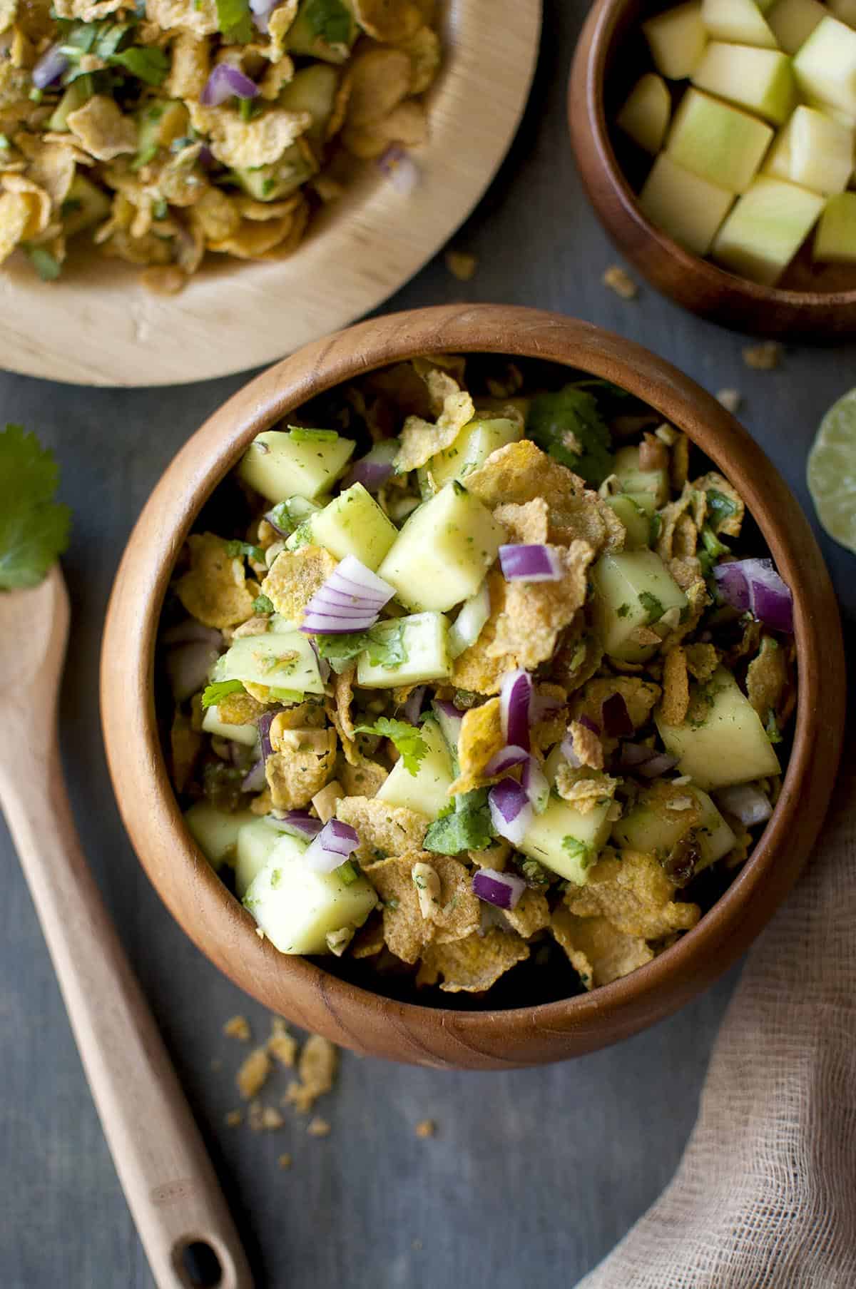 Wooden bowl with green mango and corn flakes chaat