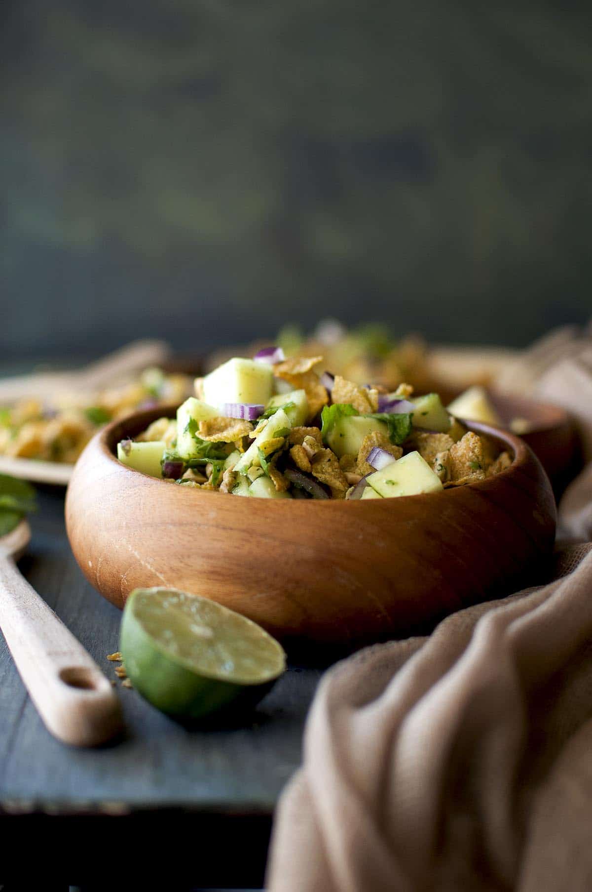 Wooden bowl with raw mango and corn flakes salad