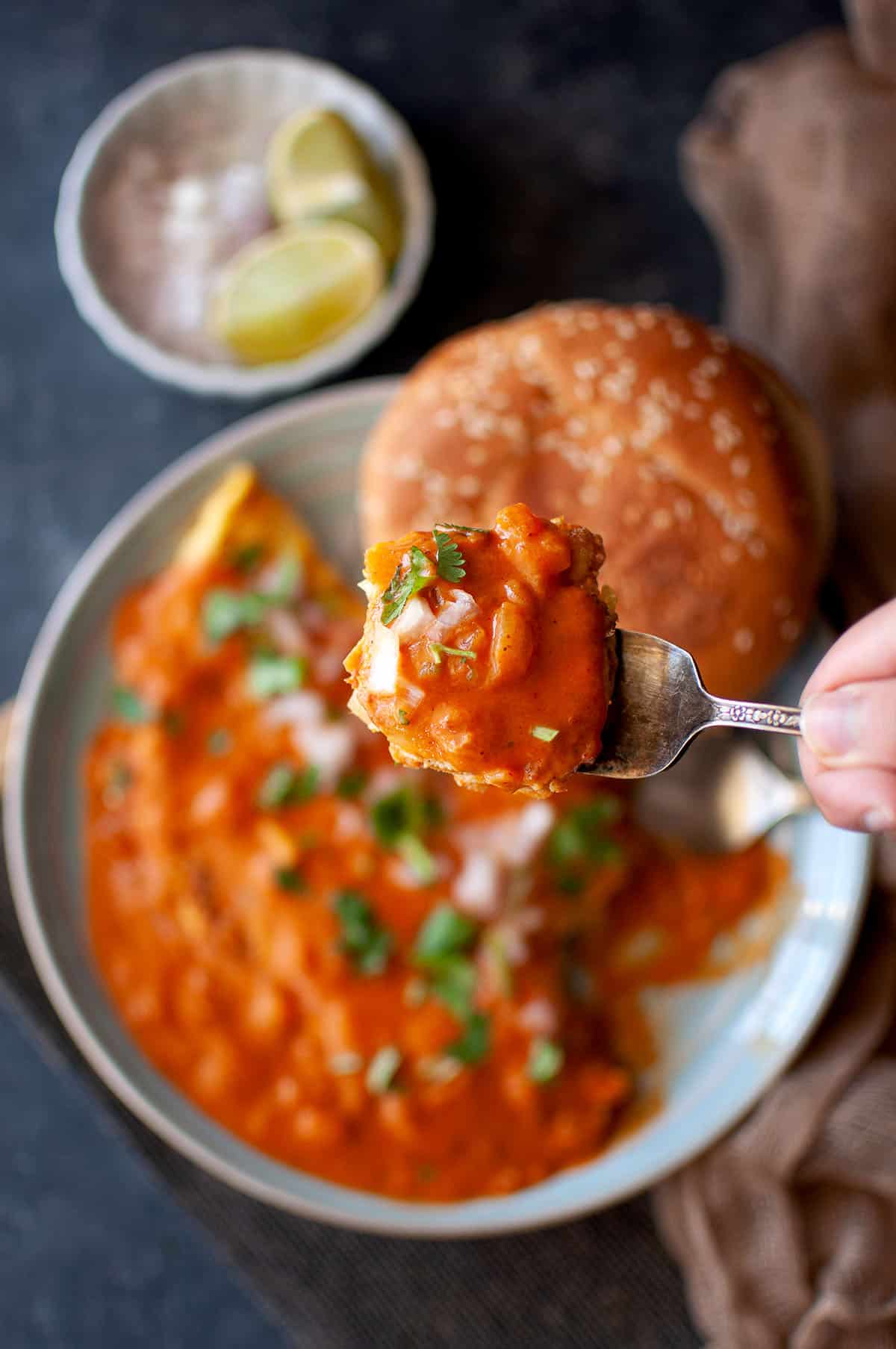 Hand holding a spoon with ras omelette.