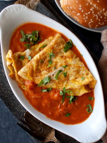 White oval bowl with ras omelette.