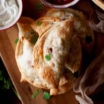 Chopping board with a stack of baked emapanadas