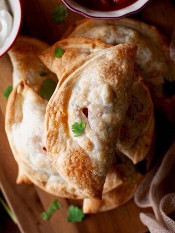 Chopping board with a stack of baked emapanadas