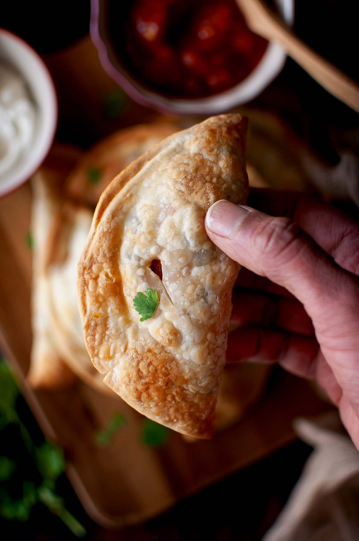 Hand holding a sweet potato empanadas