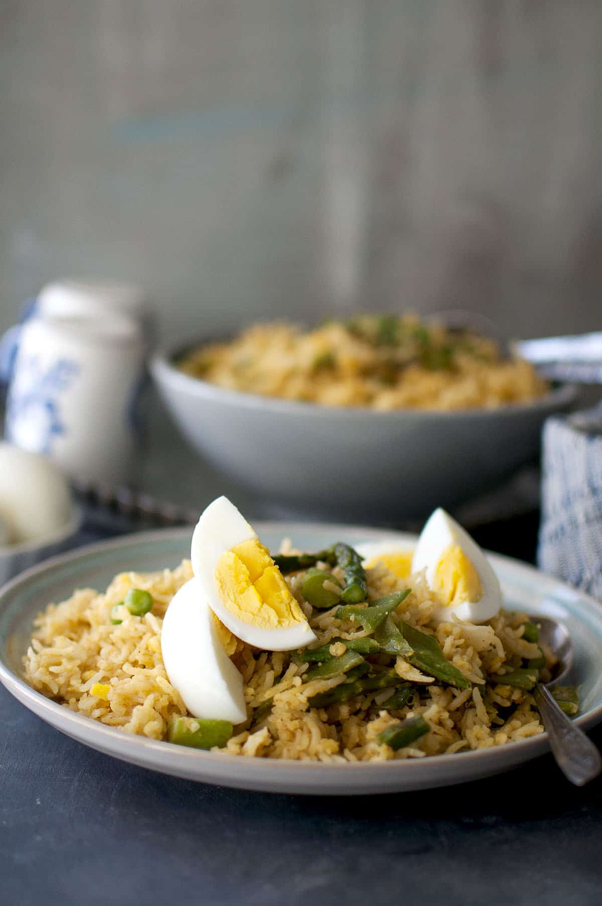 Blue plate with vegetarian kedgeree topped with asparagus and boiled eggs