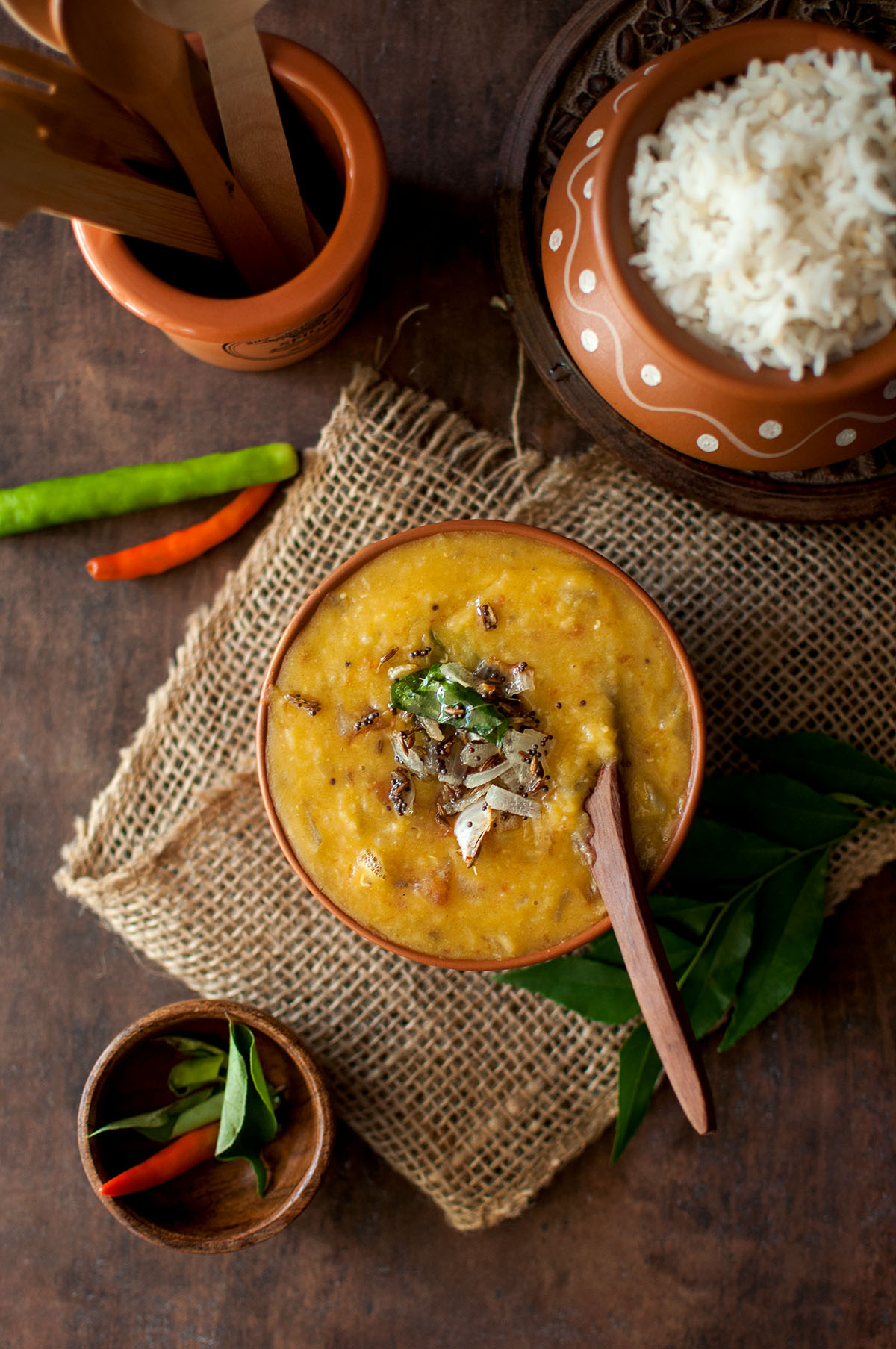 Top view of a bowl with Kerala parippu curry topped with onions.