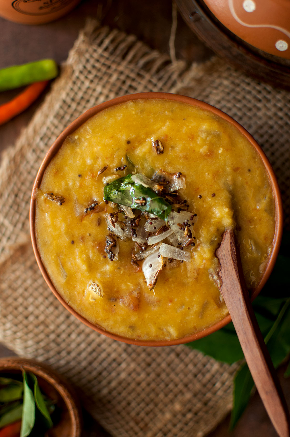 Top view of a bowl with dal curry topped with onions.