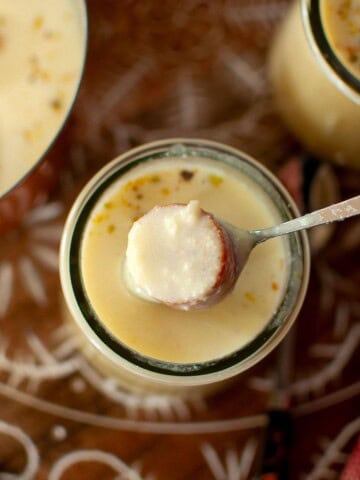 Spoon with jamun with a jar of rabri.