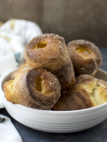 White bowl with cinnamon sugar dusted popovers