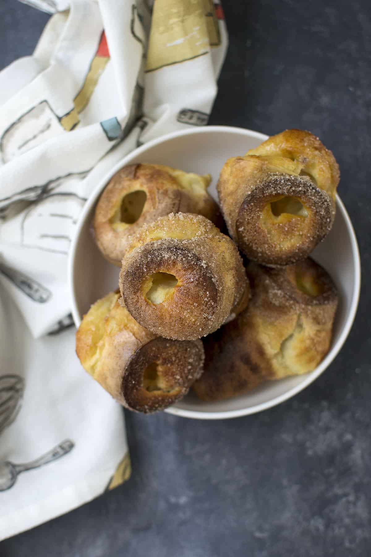 Top view of a white bowl with sourdough discard popovers