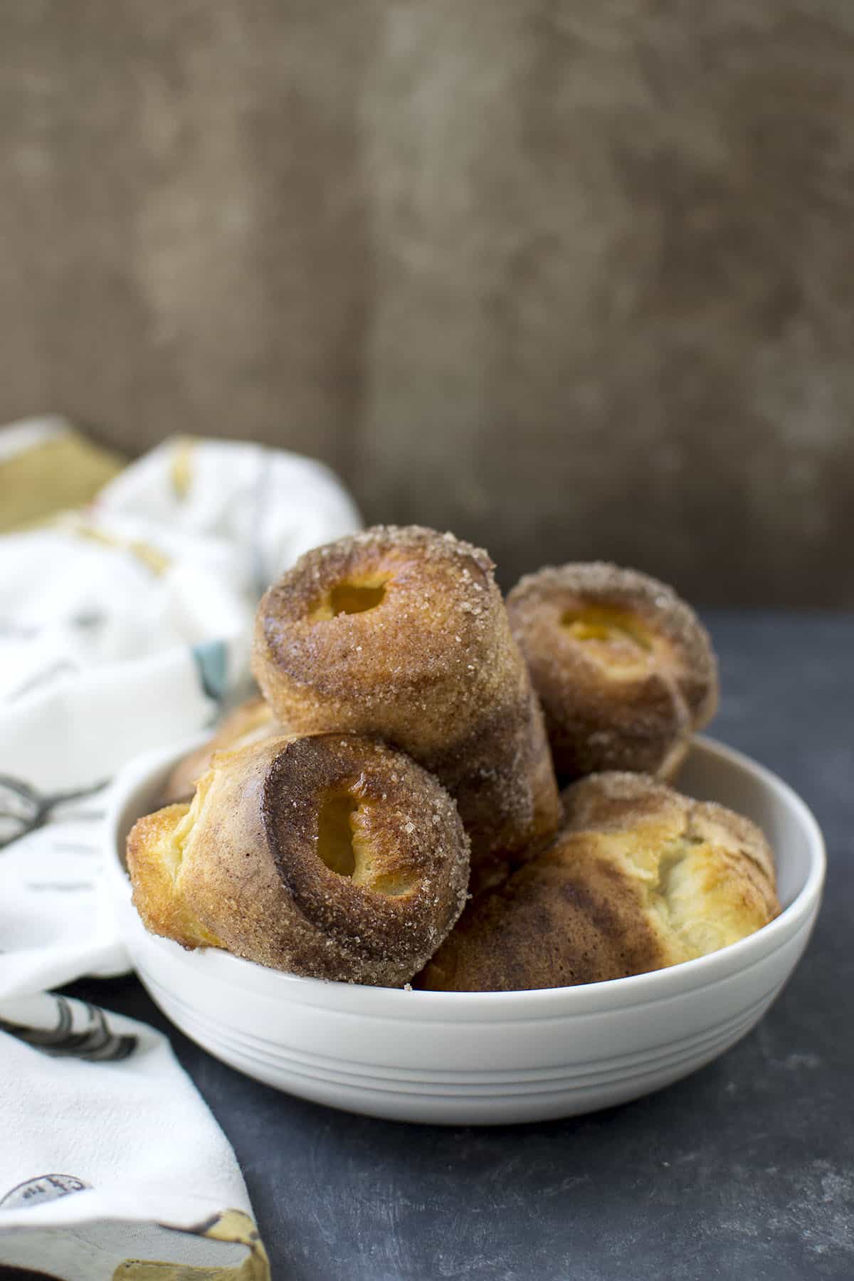White bowl with cinnamon sugar dusted popovers