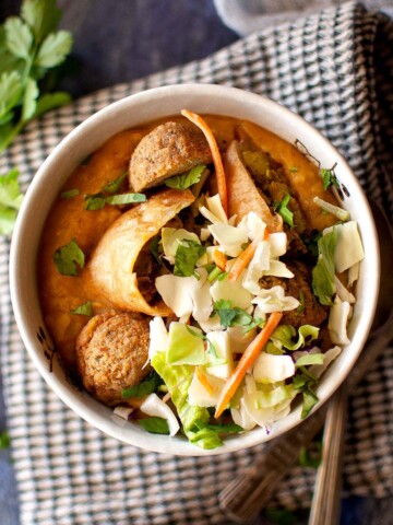 Top view of a bowl of Burmese samosa soup topped with cabbage.