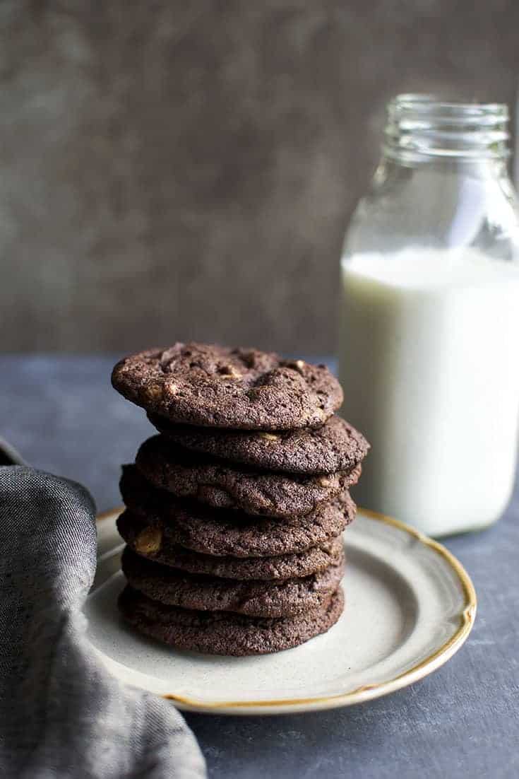 Cream plate with a stack of chocolate drop cookies and a bottle of milk in the background