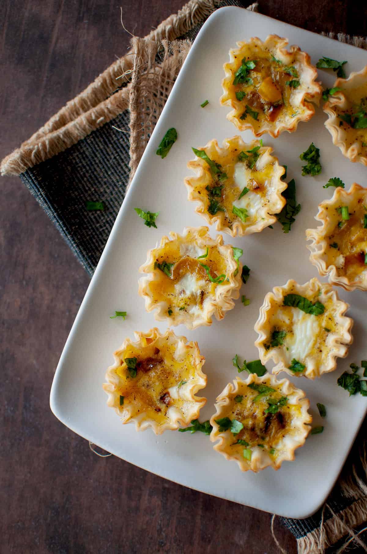 White tray with mini vegetable quiche.